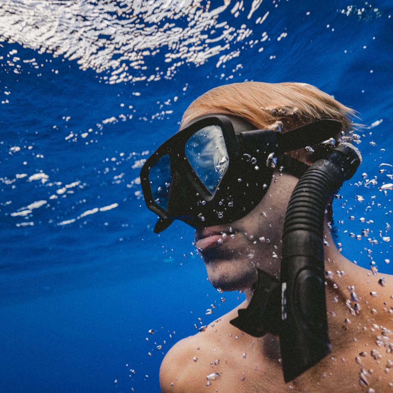 man wearing black goggles under water